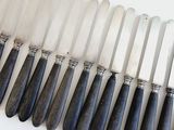 a lot of knives that are lined up on a table