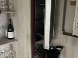 a wine cooler in the corner of a small kitchen