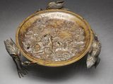 a gold plate with birds and flowers on it