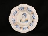 a blue and white plate with a picture of a woman on it