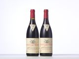 two bottles of red wine sitting next to each other on a table