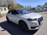 un SUV blanc garé sur un parking à côté d'un immeuble