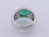 a close up of a ring with a green stone in it