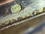 a close up of a piece of metal that has a coin on it