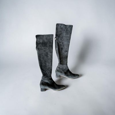 une paire de bottes en daim noir sur fond blanc