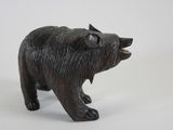a small black bear figurine on a white surface
