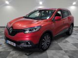 une voiture rouge garée dans un garage au sol en damier