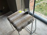 a chair with a furry seat in front of a sliding glass door