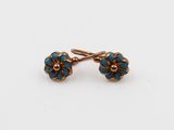 une paire de boucles d'oreilles turquoise et dorées sur fond blanc
