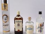 trois bouteilles d'alcool sont alignées sur une surface blanche
