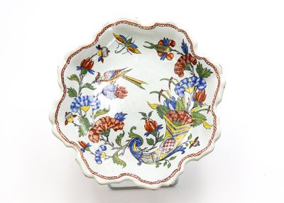 un bol blanc orné de fleurs et d'oiseaux colorés