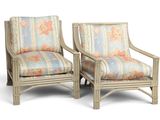 pair of rattan chairs with floral upholstered cushions