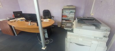 un bureau avec une imprimante posée dessus, dans une pièce
