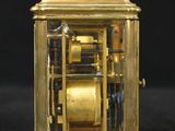 a gold clock that is sitting on a black surface
