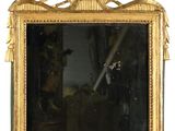 un miroir avec un cadre doré sur le mur