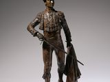 bronze statue of a man with a hat and jacket holding a bag