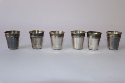 six coupes en argent sont alignées sur une surface blanche
