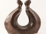 a brown sculpture of two birds on a white background
