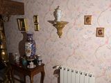 une photo d'un salon avec un radiateur et un vase posé sur une table