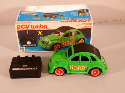 a green toy car and a green toy car in front of a box