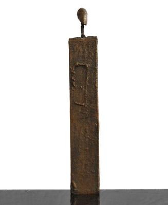 statue of a man standing on top of a wooden block with a bird perched on top of it