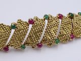 a close up of a gold bracelet with emerald and ruby stones