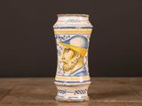 a blue and white vase with a picture of a man on it