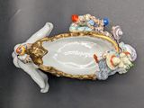 a figurine of a cat laying on top of a plate