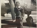 black and white photo of a man standing in front of an airplane