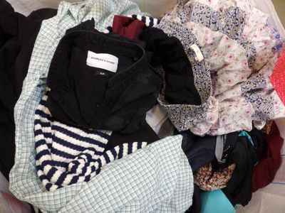 un tas de vêtements posé dans un panier posé par terre