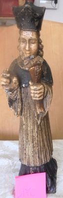 a statue of a man with a hat on holding a cell phone