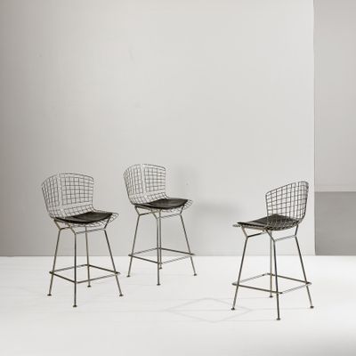 three chairs in a room with a white wall and a white floor