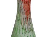 a green and red vase sitting on a white surface