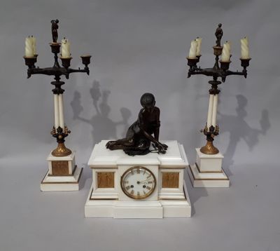 une statue représentant un homme assis sur un socle, avec une horloge