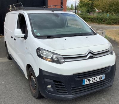 une camionnette blanche garée dans un parking