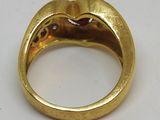 une image représentant une bague en or ornée d'un rubis au centre