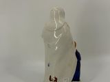 a small figurine of a man sitting on a white surface