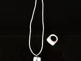 un collier blanc auquel est accroché un objet de forme carrée
