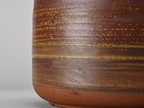 a close up of a brown vase on a white surface