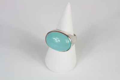 a close up of a white cone with a turquoise ring on it