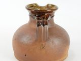 a small brown vase sitting on a white surface
