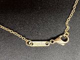 a close up of a gold necklace with a chain on a mannequin