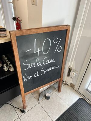 a chalk board with a price written on it in front of a door