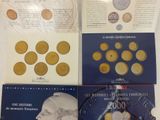 three books on a table with a picture of a man ' s face and coins