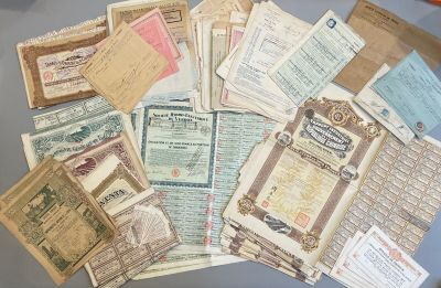 beaucoup de vieux papiers posés sur une table, avec des ciseaux