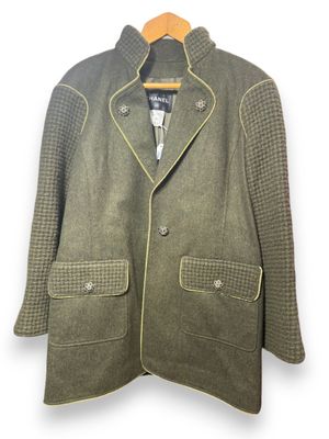 La veste est verte et présente un motif à carreaux.