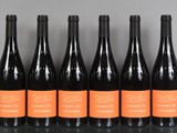 six bouteilles de vin sont alignées sur une table