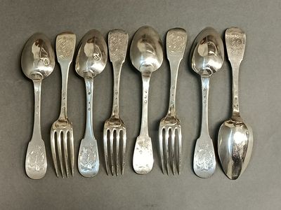 six cuillères et fourchettes en métal argenté alignées sur une table