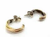two pairs of gold and silver earrings on a white surface