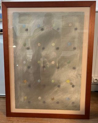 painting of a woman with dots in a frame on a wooden floor